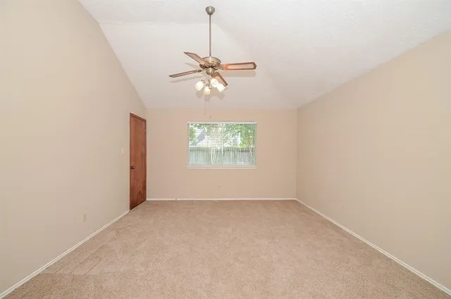 an empty room with closet and a chandelier fan