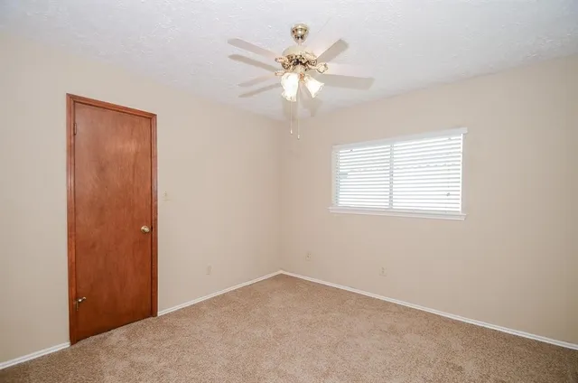 en empty room with windows and fan