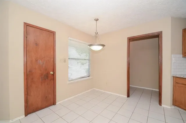 a view of an empty room with window and cabinet