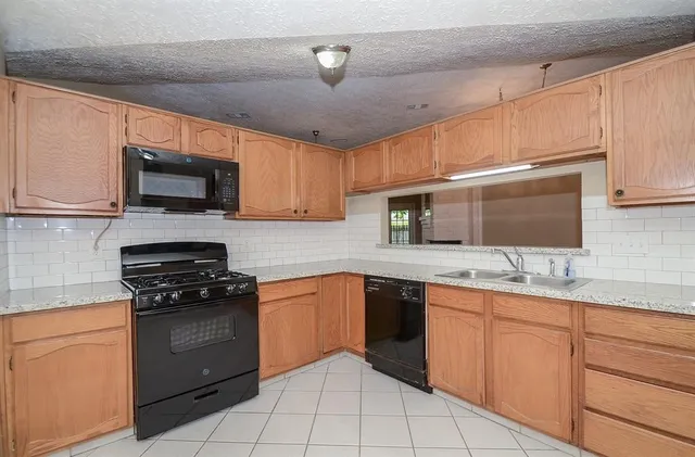 a kitchen with stainless steel appliances granite countertop a stove sink microwave and cabinets