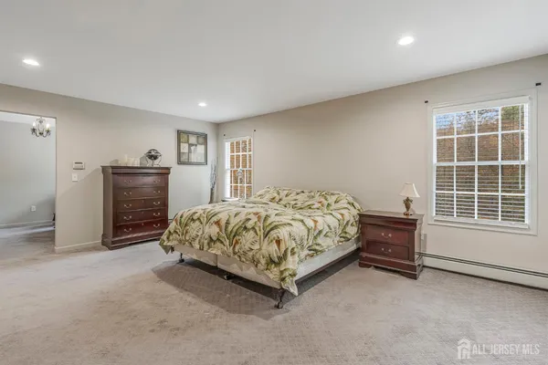 a bed sitting in a room next to a window and dresser