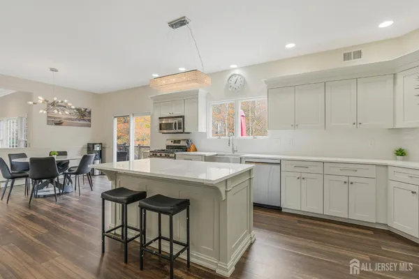 a kitchen with center island cabinets and wooden floor