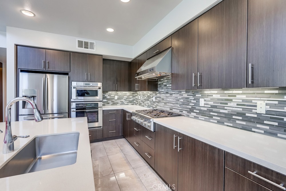 59 Gramercy Irvine, CA 92612 - Photo 16 of 71 a kitchen with stainless steel appliances granite countertop a sink stove and refrigerator