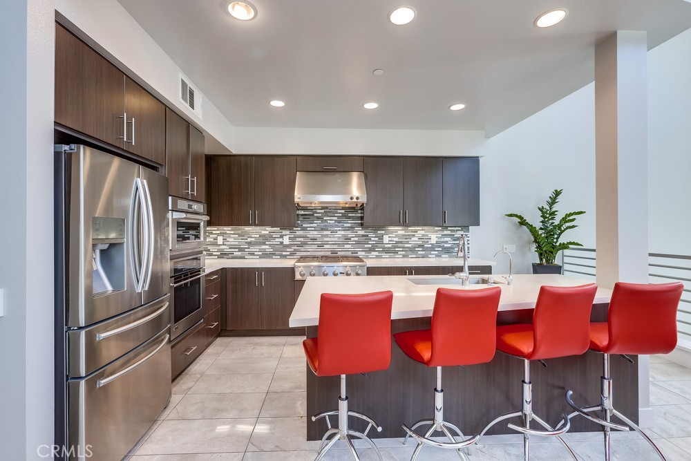 59 Gramercy Irvine, CA 92612 - Photo 22 of 71 a kitchen with granite countertop stainless steel appliances a refrigerator and chairs