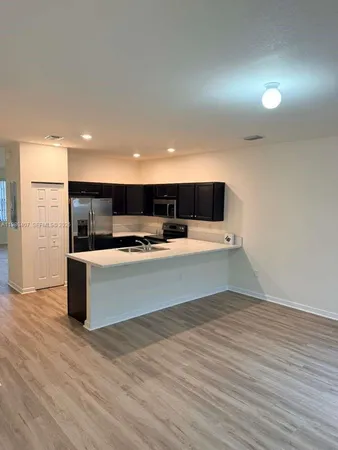 a view of kitchen with stainless steel appliances kitchen island a large counter top and a stove top oven