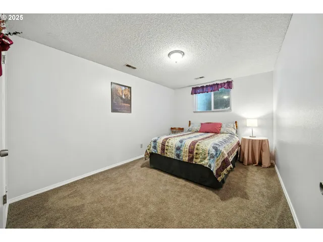 a bedroom with a bed and a painting on the wall