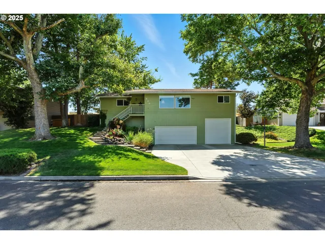 a view of a backyard with table and chairs and a barbeque with wooden fence