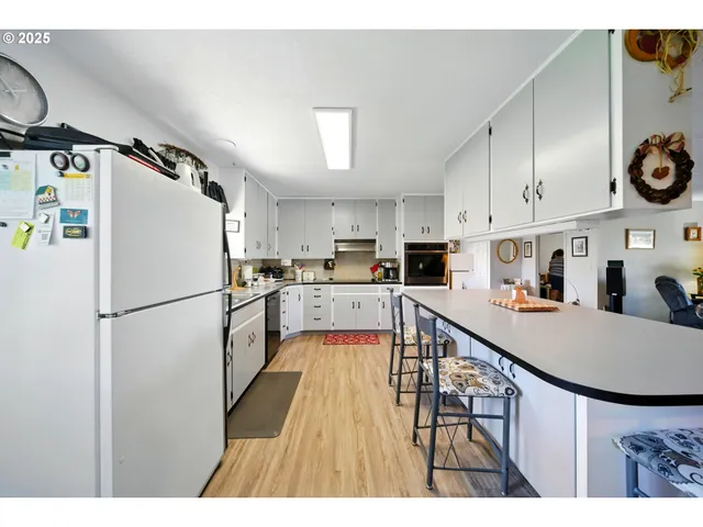 a kitchen with kitchen island a counter top space a refrigerator a stove a microwave and cabinets