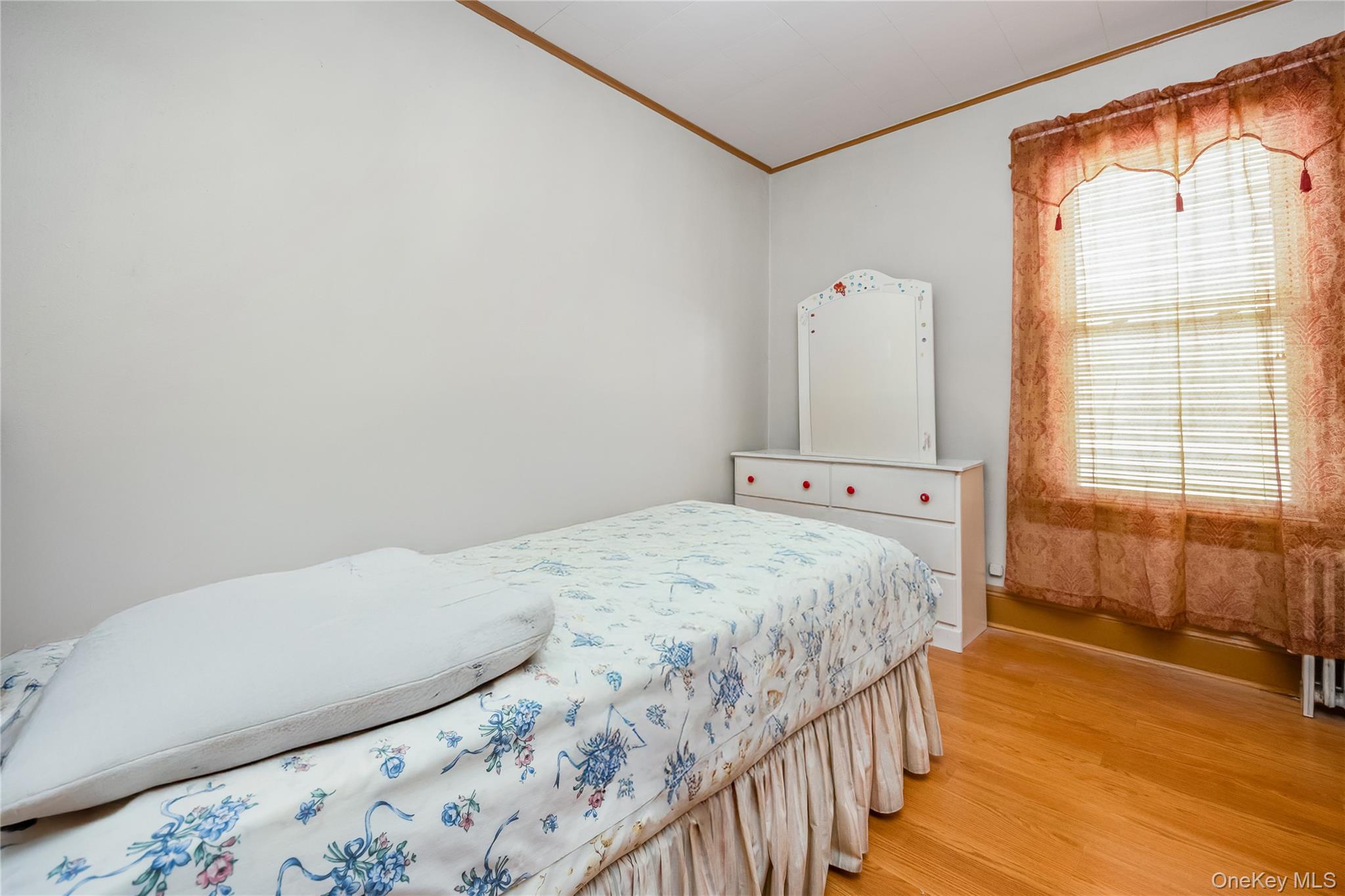 80-50 88th Road Queens, NY 11421 - Photo 15 of 21 a bedroom with a bed and wooden floor