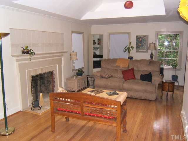 1213 Lorimer Road Raleigh, NC 27606 - Photo 5 of 20 Living Room with hardwood floors, large skylight, and custom tile work around fireplace.