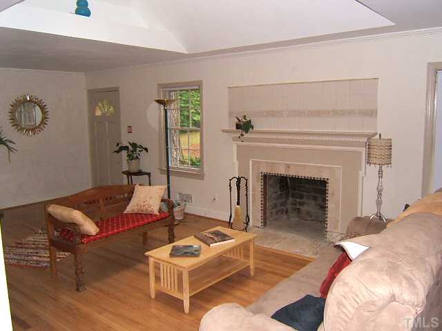 1213 Lorimer Road Raleigh, NC 27606 - Photo 6 of 20 Living Room with hardwood floors, large skylight, and custom tile work around fireplace.