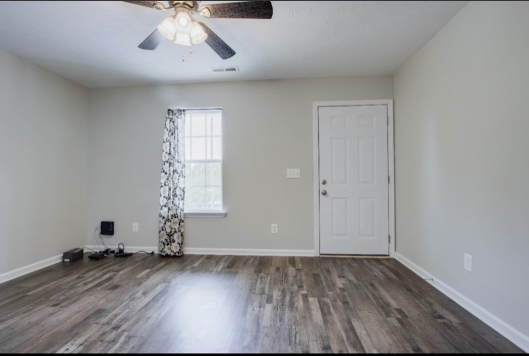 113 Bright Avenue Carthage, TN 37030 - Photo 4 of 14 an empty room with wooden floor and windows