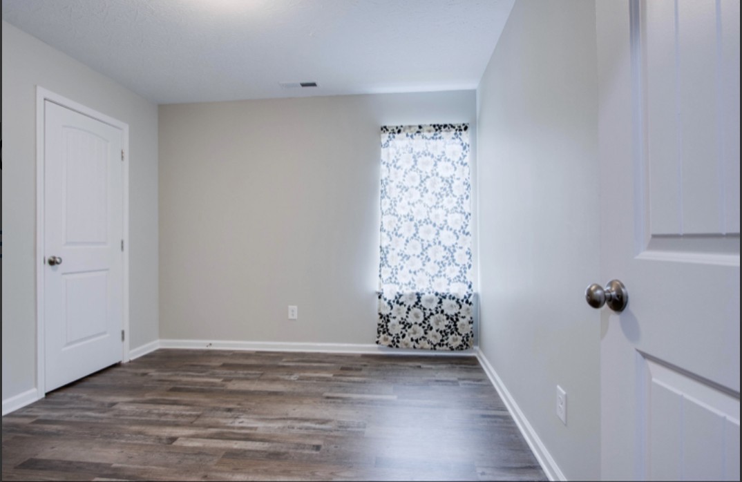 113 Bright Avenue Carthage, TN 37030 - Photo 7 of 14 a view of an empty room with wooden floor and a window