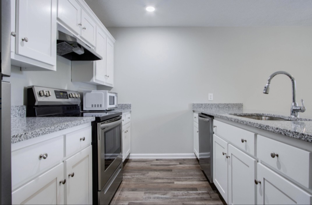 113 Bright Avenue Carthage, TN 37030 - Photo 9 of 14 a kitchen with granite countertop a sink stainless steel appliances and white cabinets