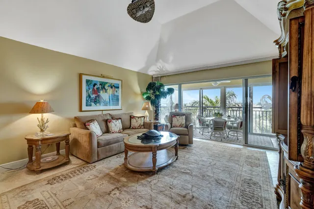 a living room with furniture a lamp a rug and a large window