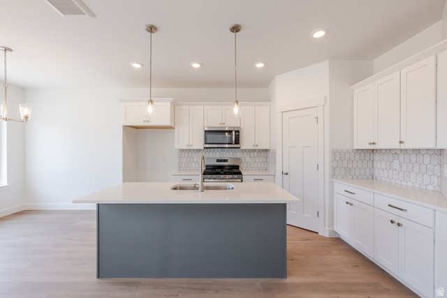 5228 South Acacia Drive, Unit 808 Mapleton, UT 84664 - Photo 7 of 22 Modern kitchen featuring a central island with a quartz countertop and integrated sink