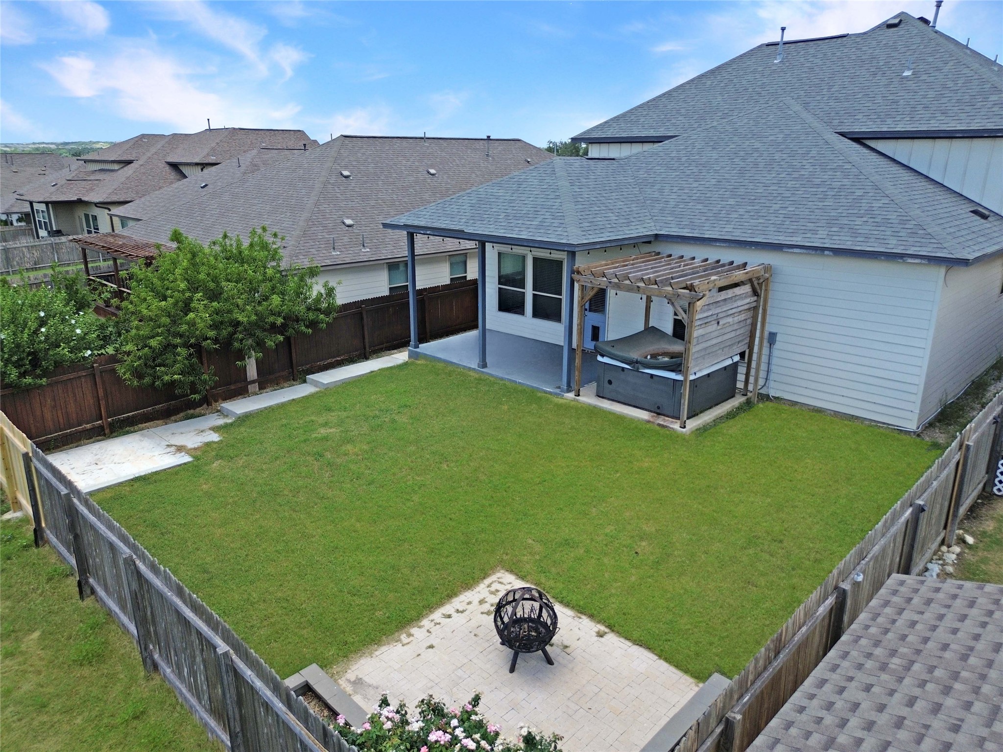 429 Rusk Bluff Avenue Leander, TX 78641 - Photo 19 of 24 A private backyard oasis features a patio with a pergola-covered spa, ideal for relaxation and entertaining.