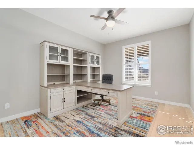 a view of a workspace with furniture and a window
