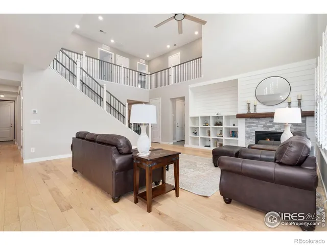 a living room with fireplace furniture and a large window