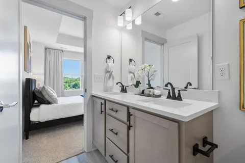 a en suite bathroom with a double vanity sink and a mirror