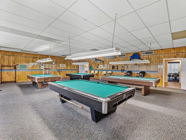 a room with pool table and windows
