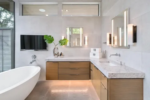 a bathroom with a granite countertop sink a bathtub a mirror and vanity