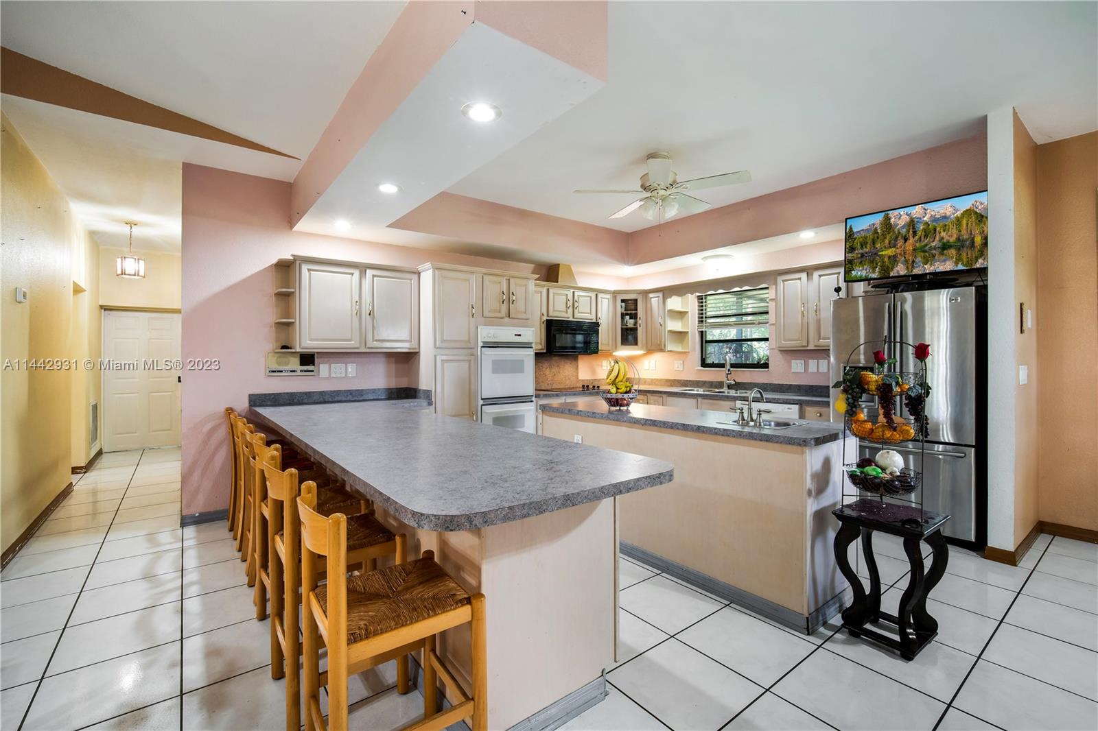 18475 Southwest 206th Street Miami, FL 33187 - Photo 19 of 49 a kitchen with stainless steel appliances kitchen island granite countertop a table chairs sink and cabinets