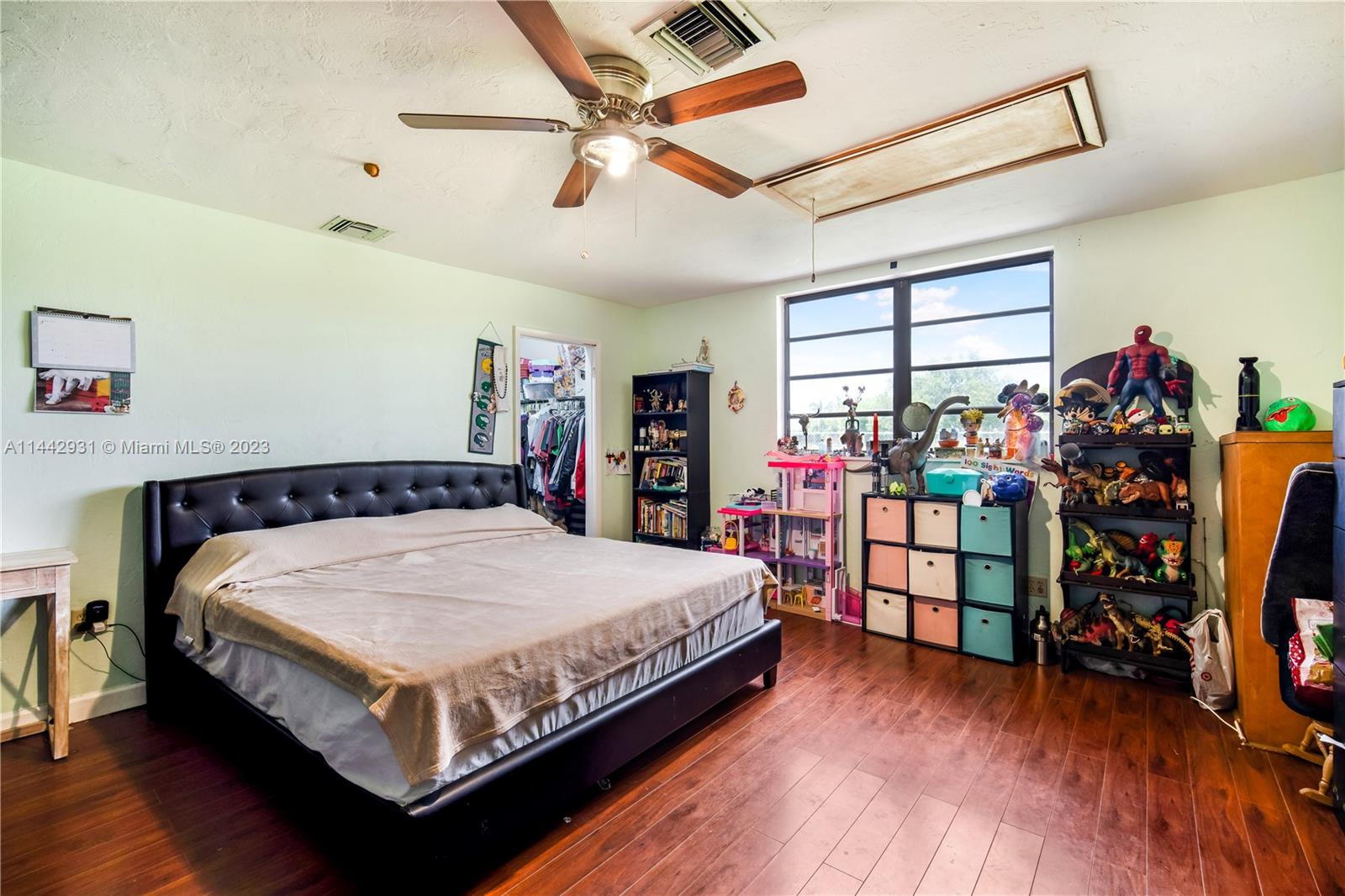 18475 Southwest 206th Street Miami, FL 33187 - Photo 36 of 49 a bed sitting in a bedroom next to a window and a chandelier