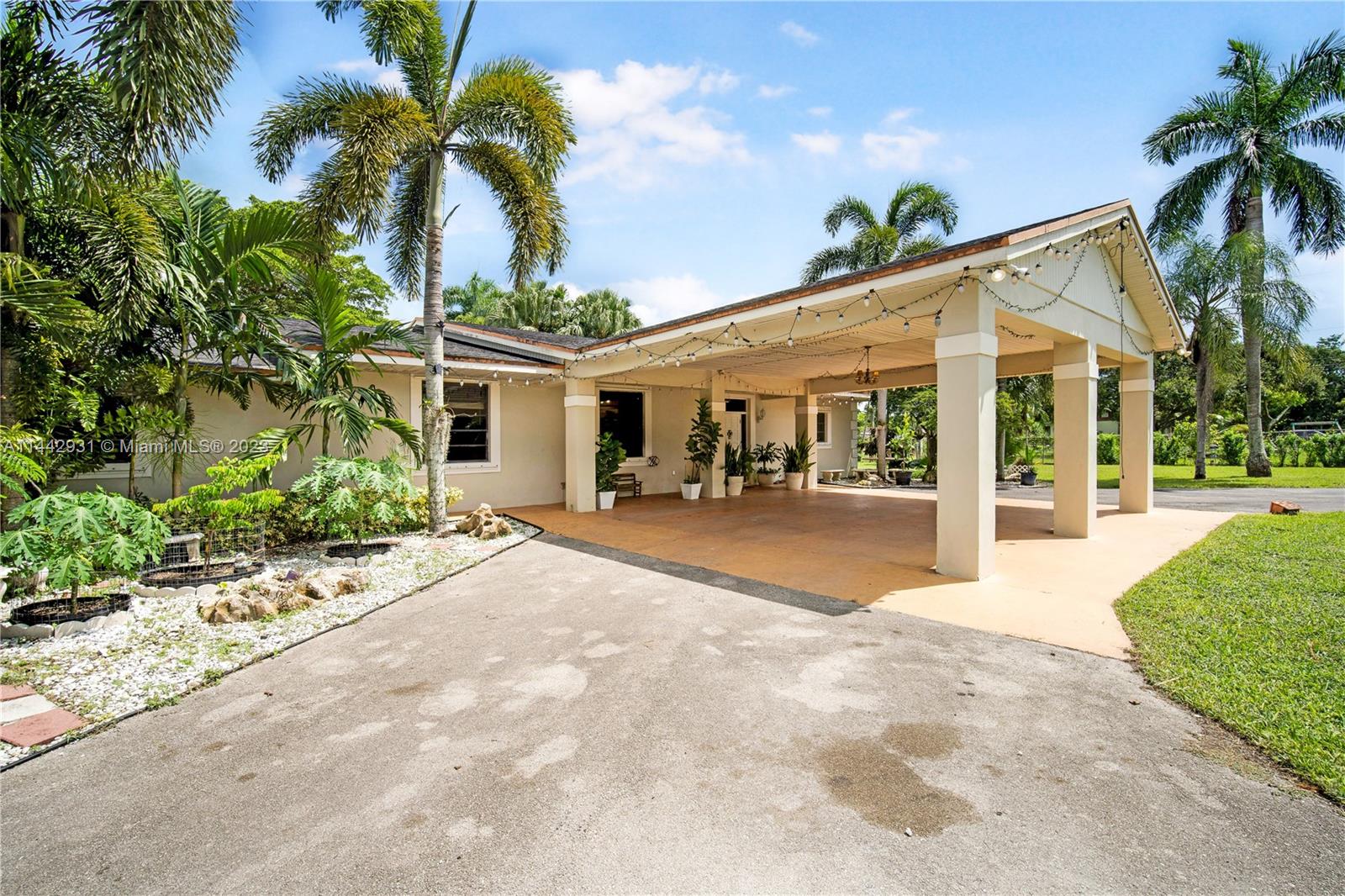 18475 Southwest 206th Street Miami, FL 33187 - Photo 8 of 49 a view of a white house with a large windows and palm trees