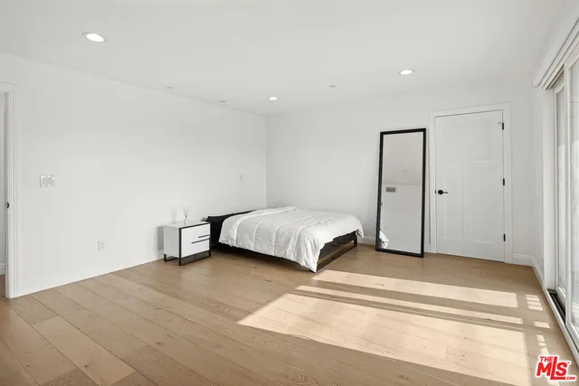 a spacious bedroom with a bed and a rug