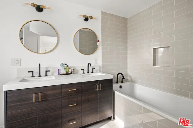 a bathroom with a double vanity sink and a mirror