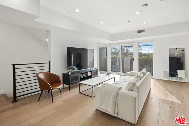 a living room with furniture a flat screen tv and a large window
