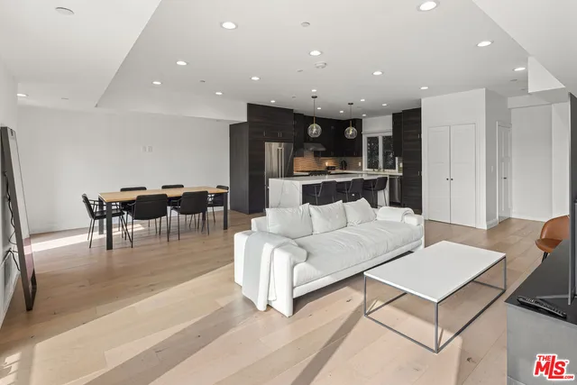 a living room with furniture a dining table and kitchen view