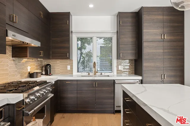 a kitchen with a sink stove top oven and cabinets