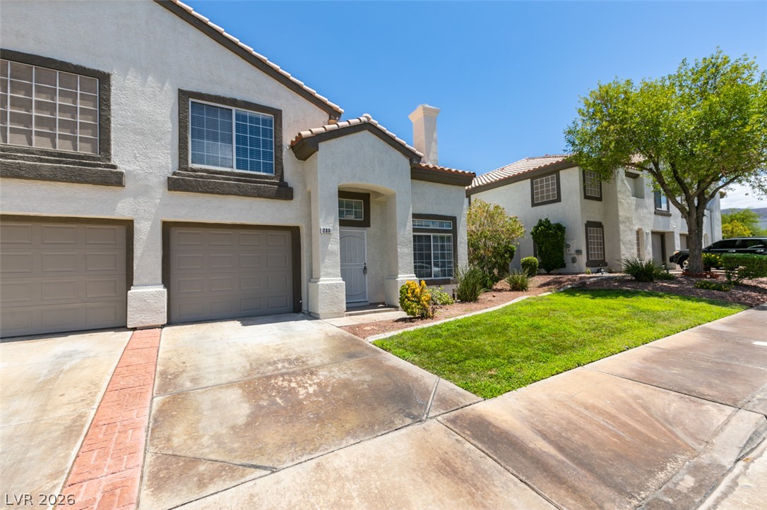 200 Luninborg Street Henderson, NV 89074 - Photo 4 of 40 A welcoming front entrance, complete with an attached garage and well-maintained lawn.