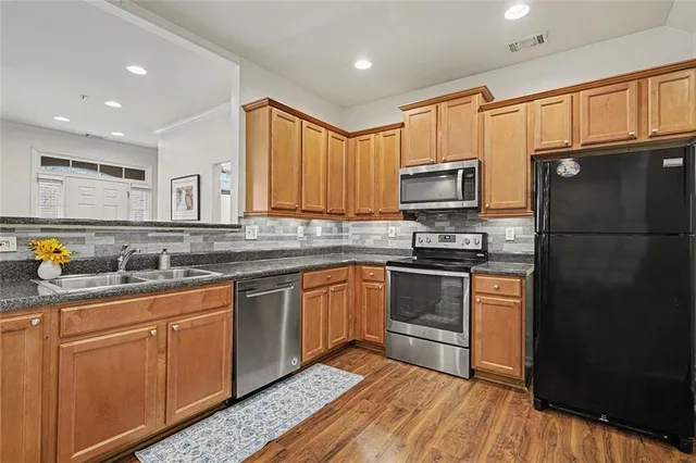 a kitchen with granite countertop stainless steel appliances and wooden cabinets