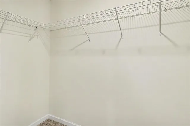 a view of an empty room with a window and a bookshelf
