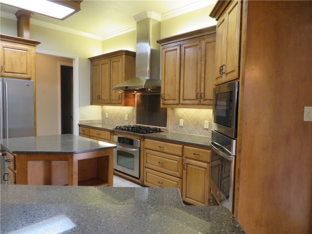 5803 South Oso Parkway Corpus Christi, TX 78414 - Photo 16 of 39 a kitchen with stainless steel appliances granite countertop a refrigerator and a stove top oven