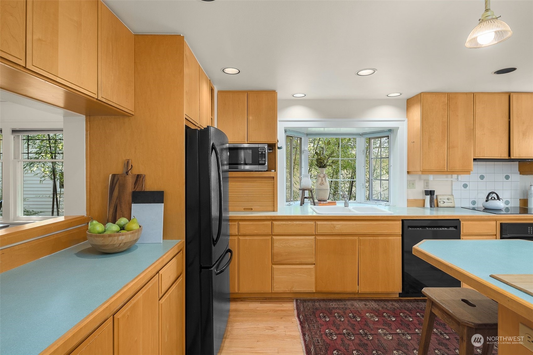 4229 Eastern Avenue North Seattle, WA 98103 - Photo 8 of 32 a kitchen with stainless steel appliances granite countertop a sink cabinets and wooden floor