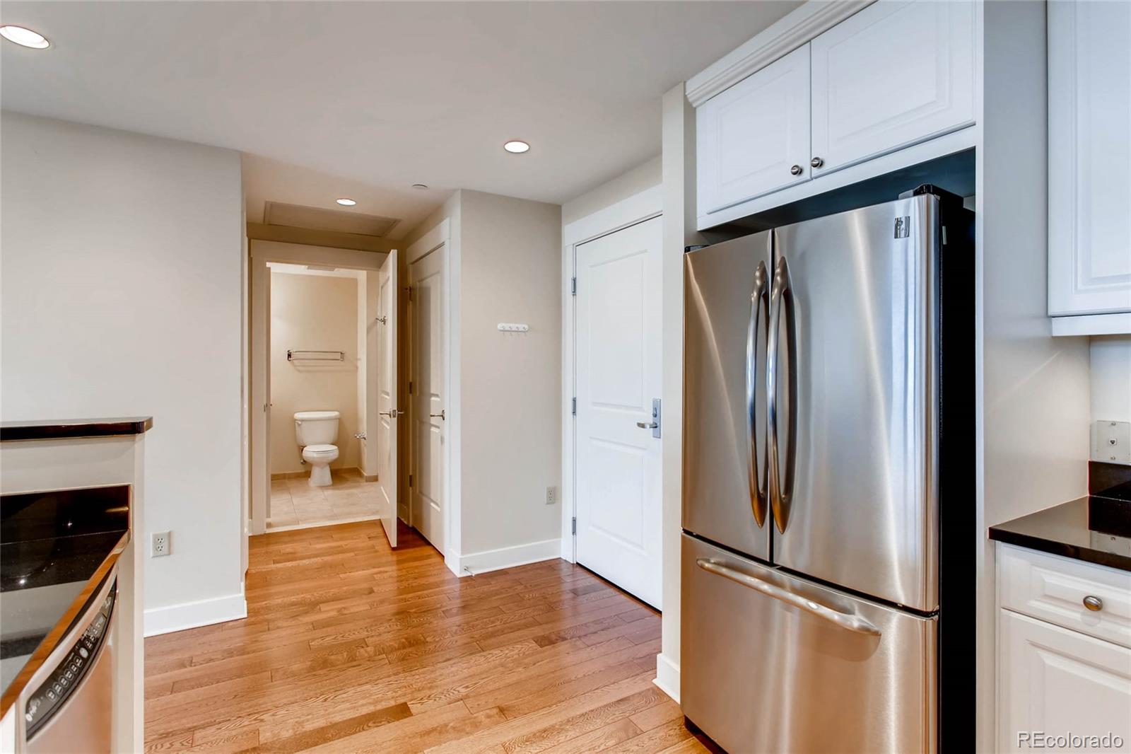 7220 W. Bonfils Lane, Unit 410 Lakewood, CO 80226 - Photo 13 of 27 a view of a kitchen with refrigerator and wooden floor