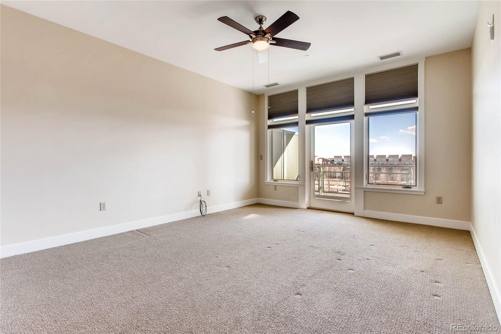 7220 W. Bonfils Lane, Unit 410 Lakewood, CO 80226 - Photo 14 of 27 an empty room with windows and ceiling fan