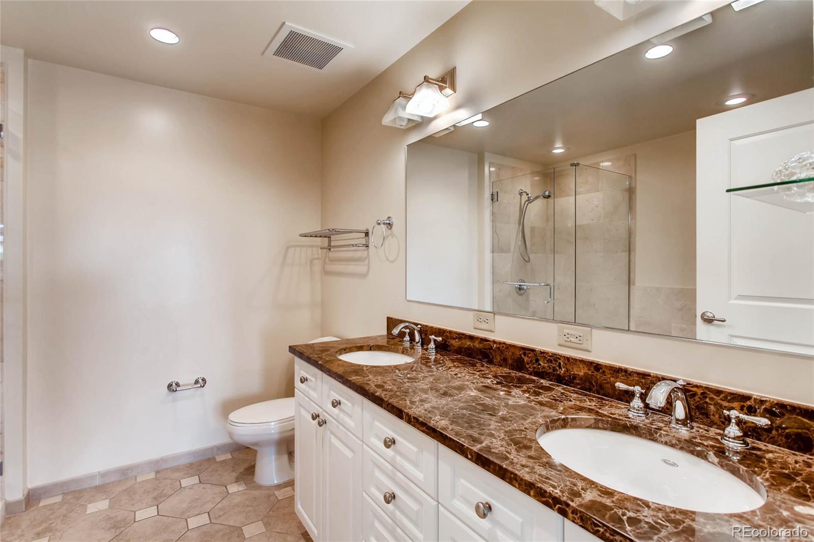 7220 W. Bonfils Lane, Unit 410 Lakewood, CO 80226 - Photo 17 of 27 a bathroom with a granite countertop double vanity sink and mirror
