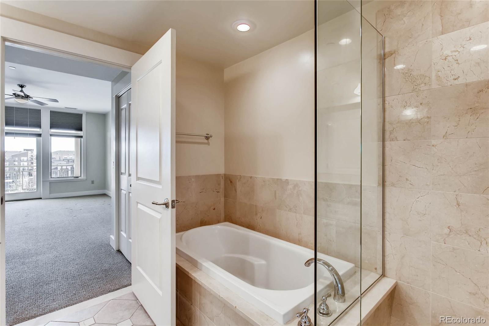 7220 W. Bonfils Lane, Unit 410 Lakewood, CO 80226 - Photo 18 of 27 a bathroom with a bathtub and shower