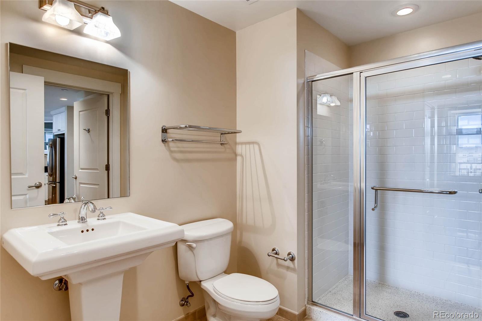 7220 W. Bonfils Lane, Unit 410 Lakewood, CO 80226 - Photo 21 of 27 a bathroom with a toilet a sink and mirror