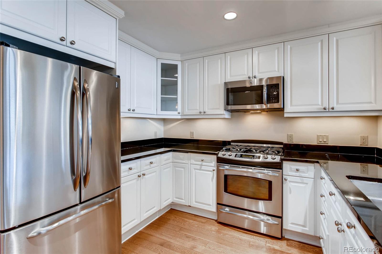 7220 W. Bonfils Lane, Unit 410 Lakewood, CO 80226 - Photo 10 of 27 a kitchen with granite countertop white cabinets and stainless steel appliances