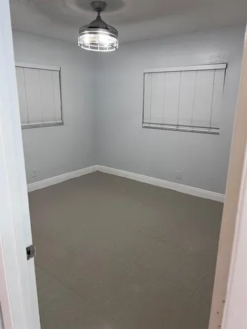 an empty room with chandelier fan