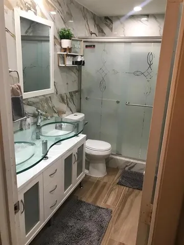 a bathroom with a granite countertop sink toilet and shower