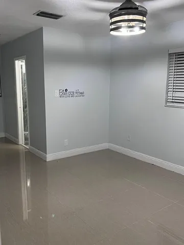 an empty room with windows and chandelier