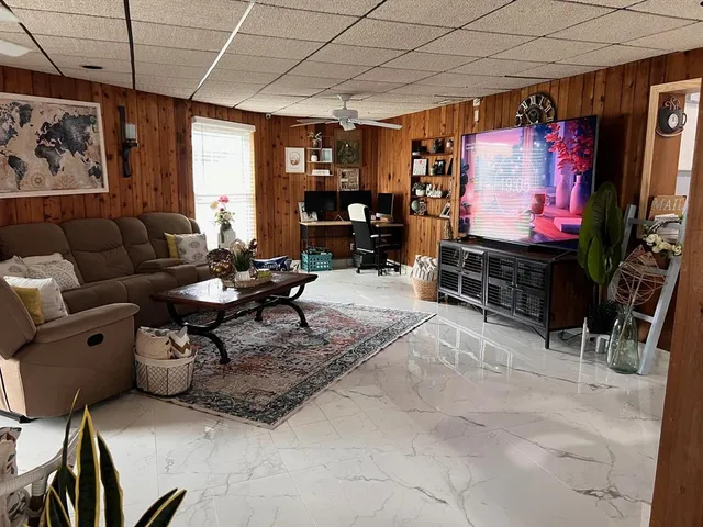 a living room with furniture a flat screen tv and a window