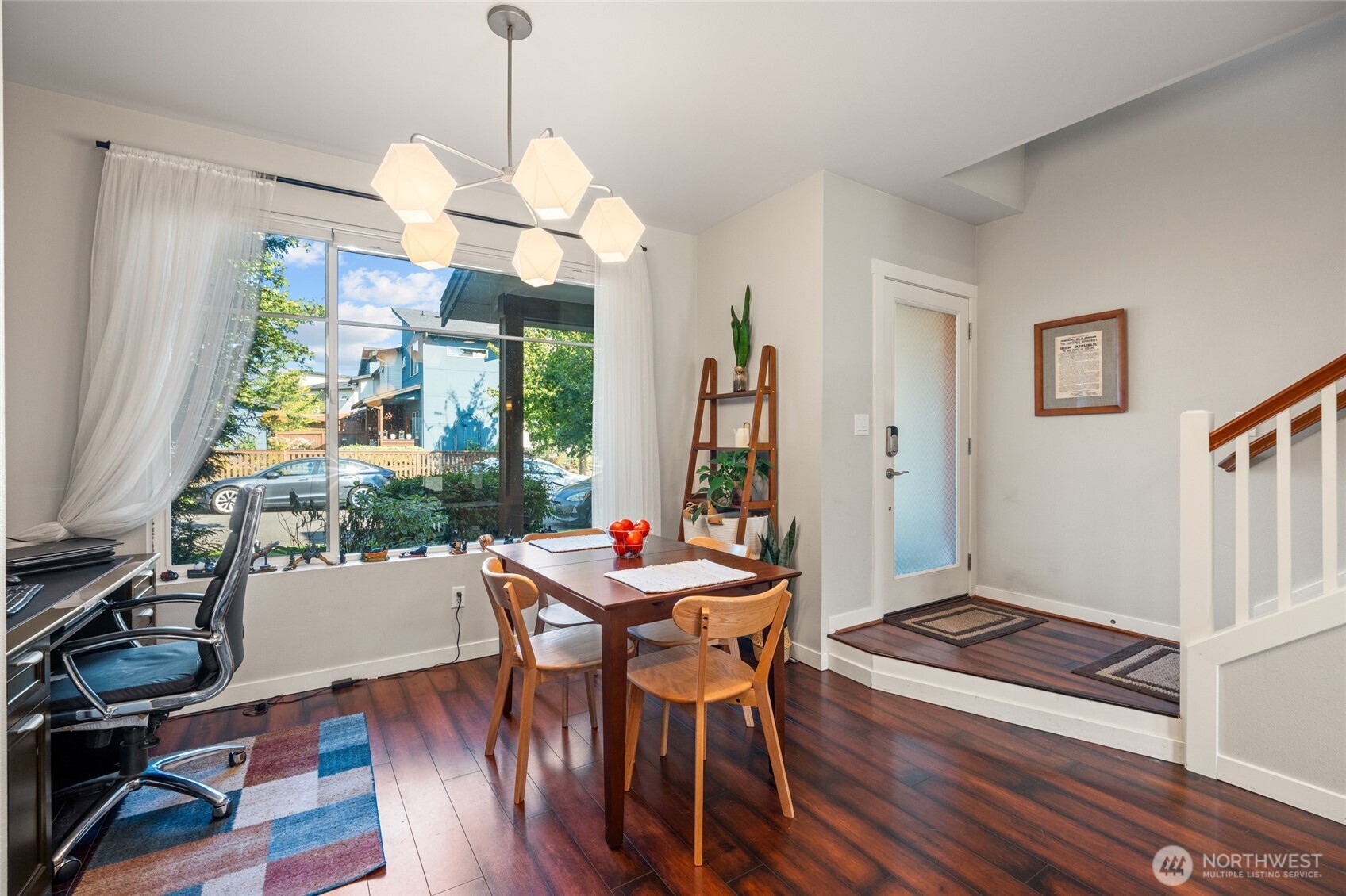 3013 South Nevada Street Seattle, WA 98108 - Photo 9 of 33 a dining room with wooden floor a chandelier a wooden table and chairs